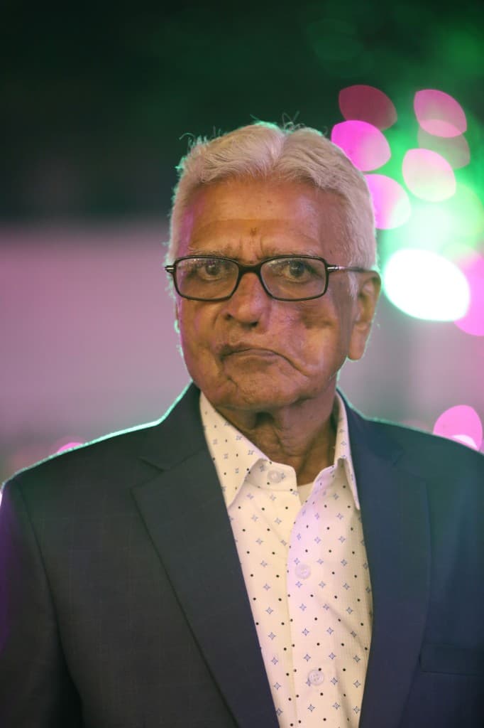 Portrait of Late Shri Om Prakash Ji Khandelwal, in a navy blazer and patterned shirt